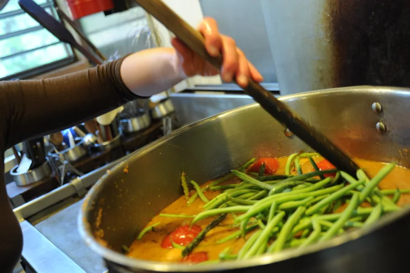Grande marmite de plat mijoté aux haricots verts et tomates, idéal à préparer en batch