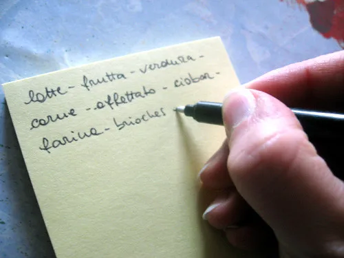Liste de courses manuscrite posee sur un plan de travail
