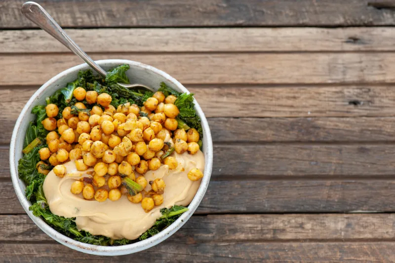 Bol végétarien de pois chiches rôtis, chou kale et houmous, un dîner sans viande complet
